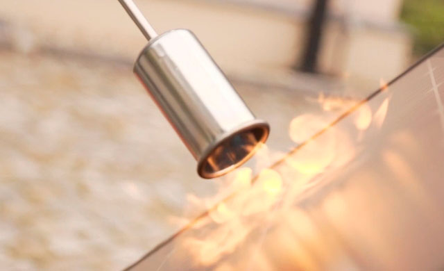 Standbild aus einem Video, das zeigt, wie ein Schweißbrenner versucht, ein Photovoltaik-Paneel zu verbrennen.